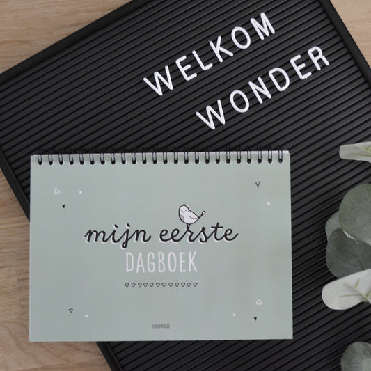 Sfeerbeeld mijn eerste dagboek groen, waarbij het gesloten boek op een letterbord ligt met de tekst Welkom wonder.