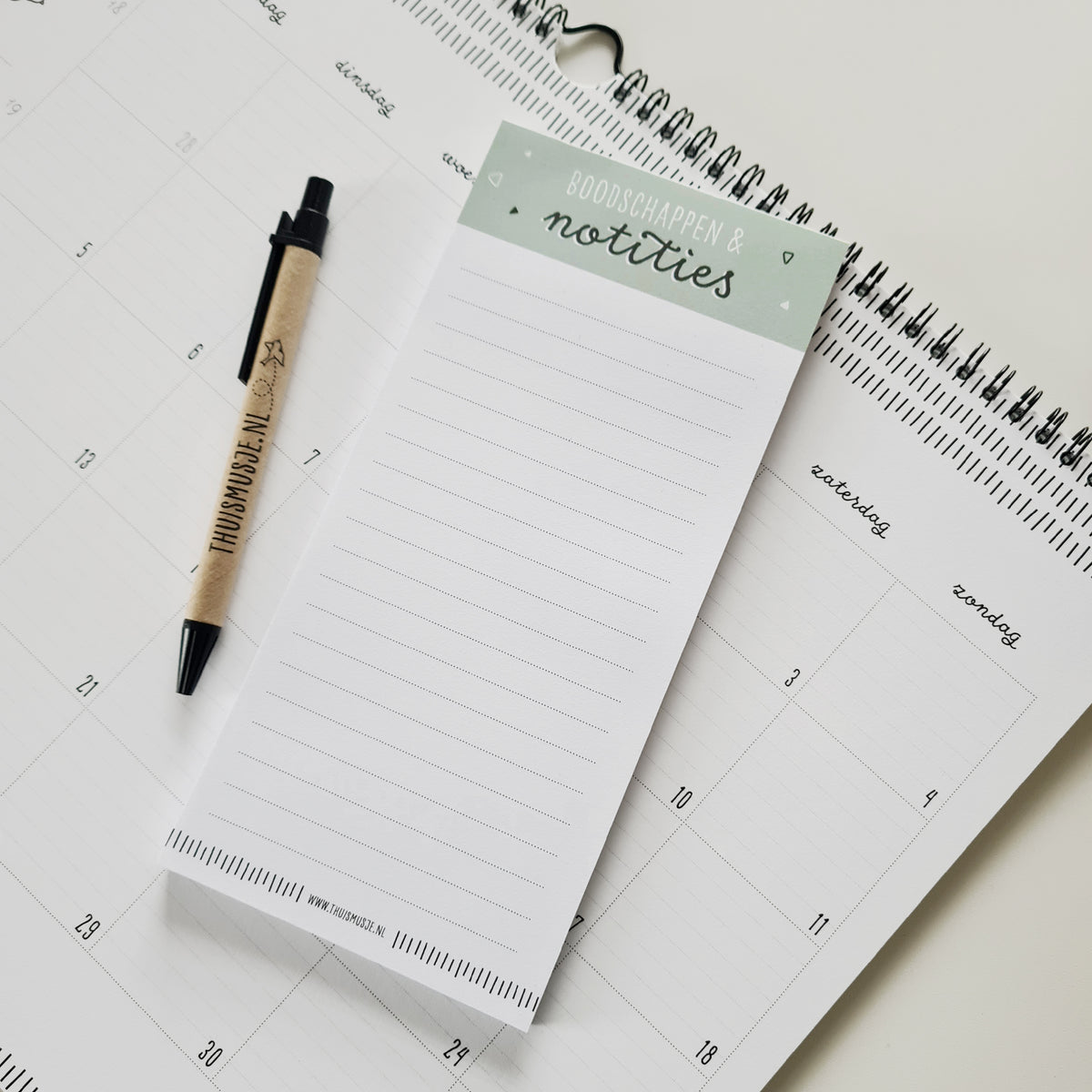 Sfeerbeeld van notitieblokje met pen en kalender. Veel schrijfruimte zichtbaar en een fijne rustige vormgeving.