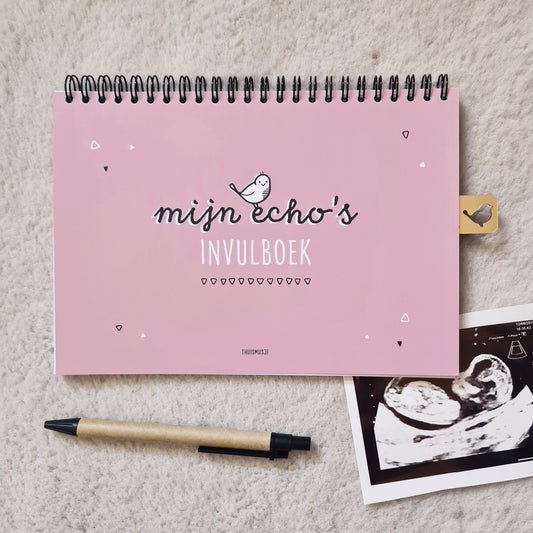 Sfeerbeeld voorzijde roze echoboekje op zacht kleed met pen en echofoto. 