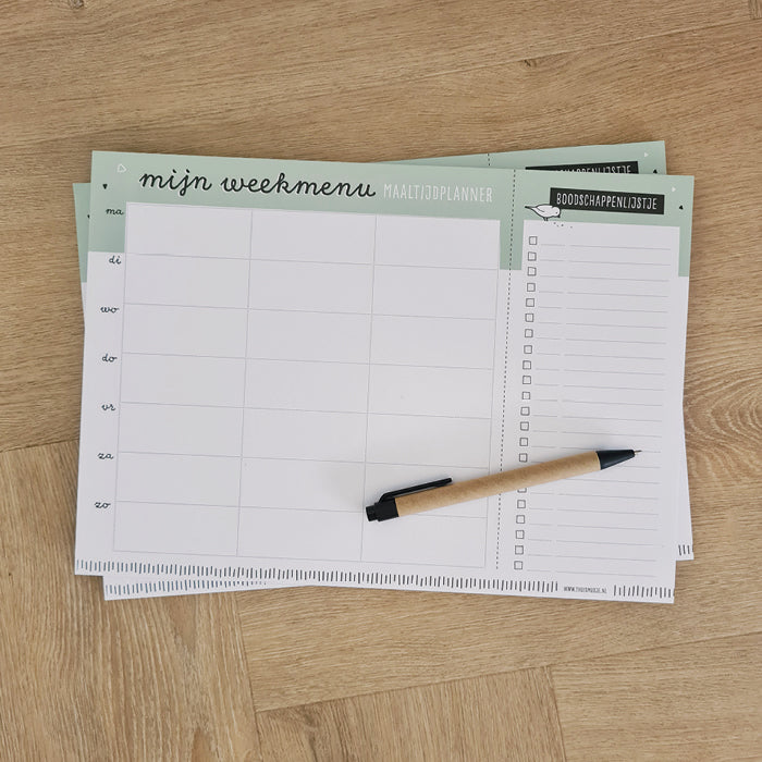 Sfeerfoto van maaltijdplanner op houten tafel met balpen er bovenop