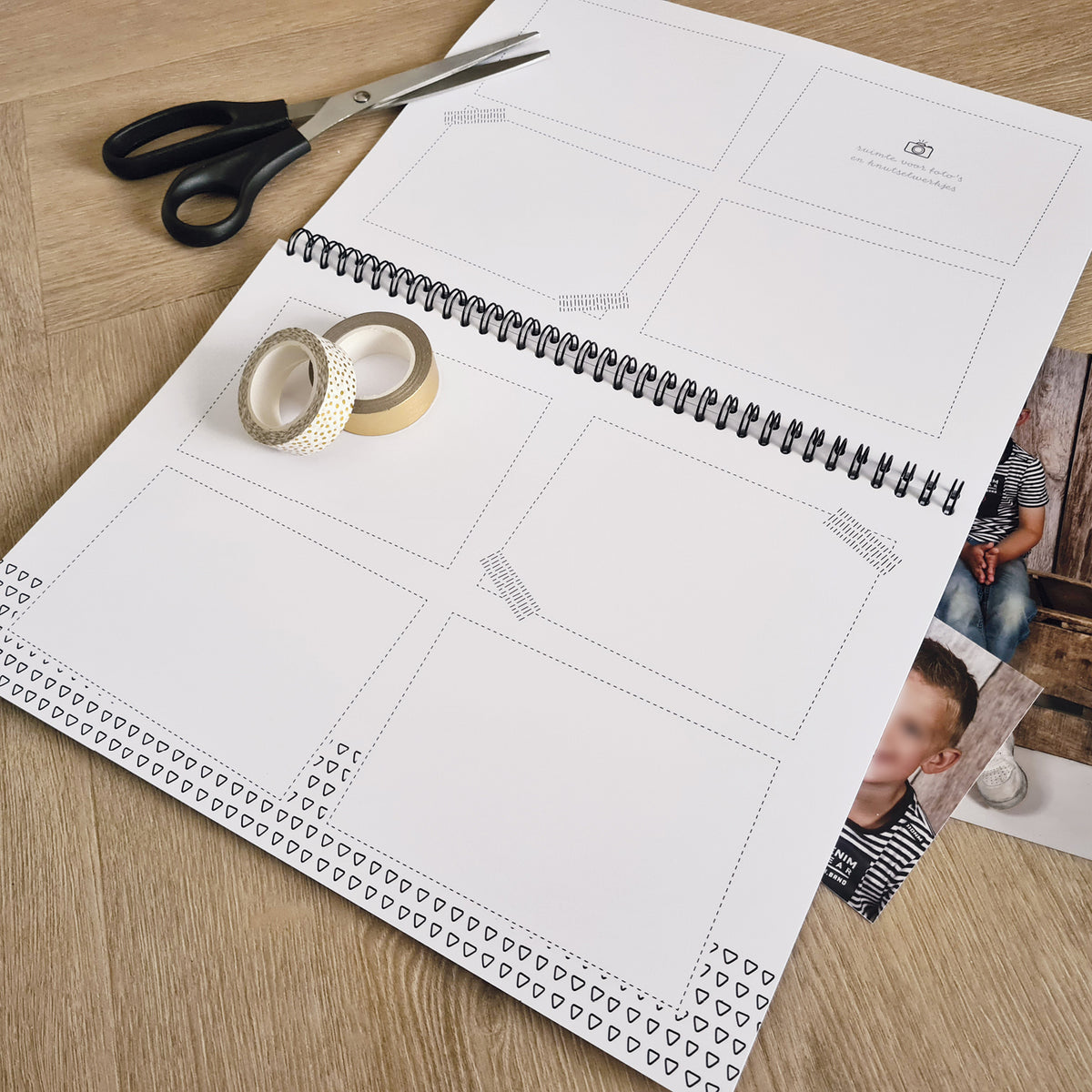 Sfeerbeeld binnenzijde schoolfotoboek op houten tafel, met schaar, washitapes en schoolfoto's. Leuk ontworpen pagina's met ruimte om foto's en knutsels in te plakken. 