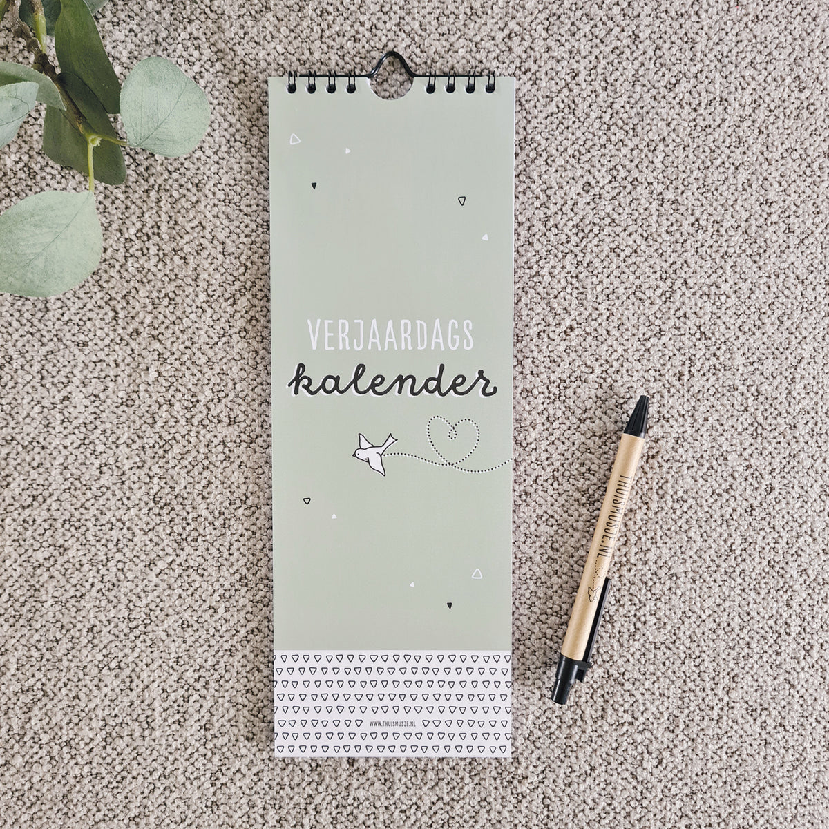 sfeerfoto van verjaardagskalender met vliegend vogeltje en hartjes stippellijn.