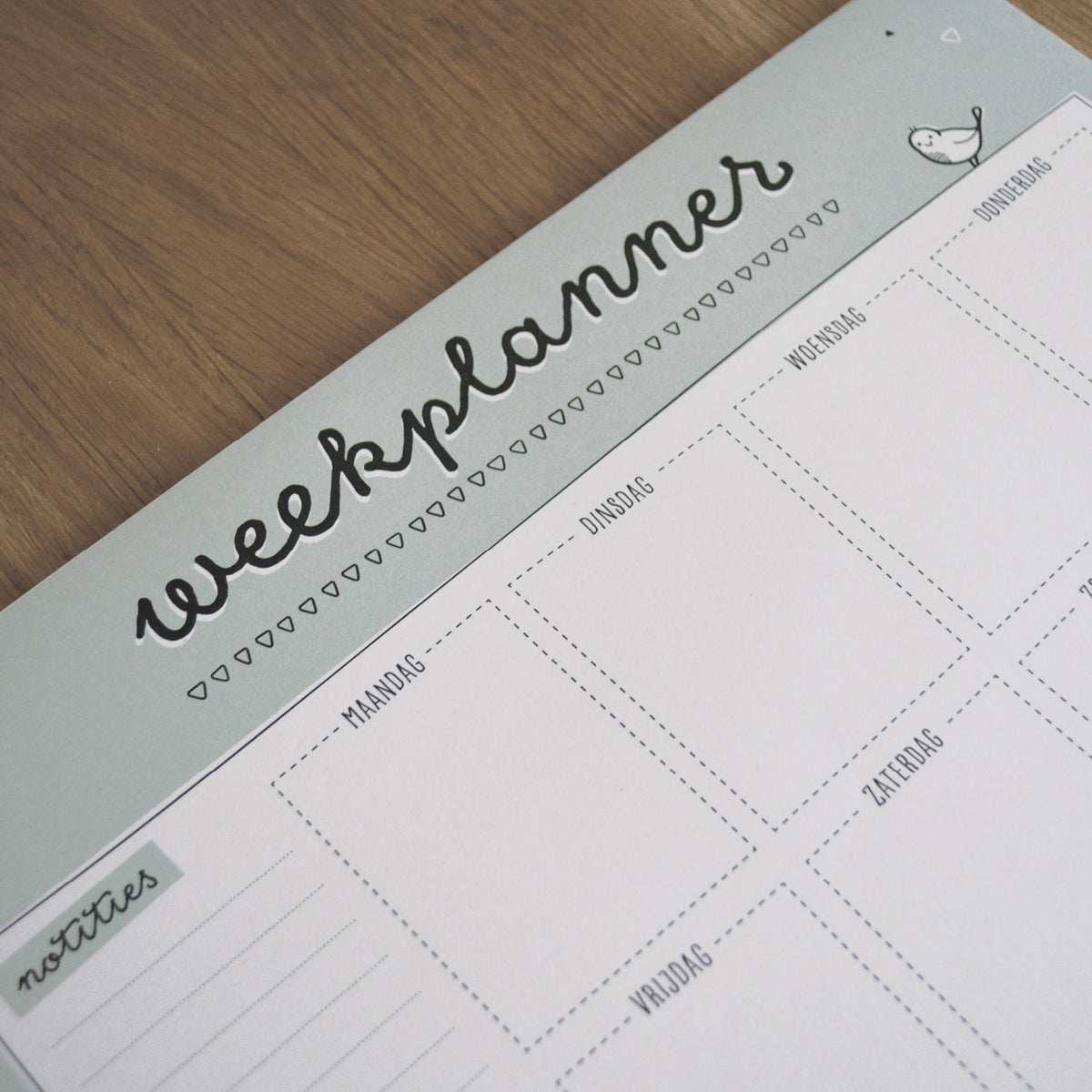 close-up van titel weekplanner in een groene balk en dagindeling. Overige ontwerp is grotendeels zwart wit.