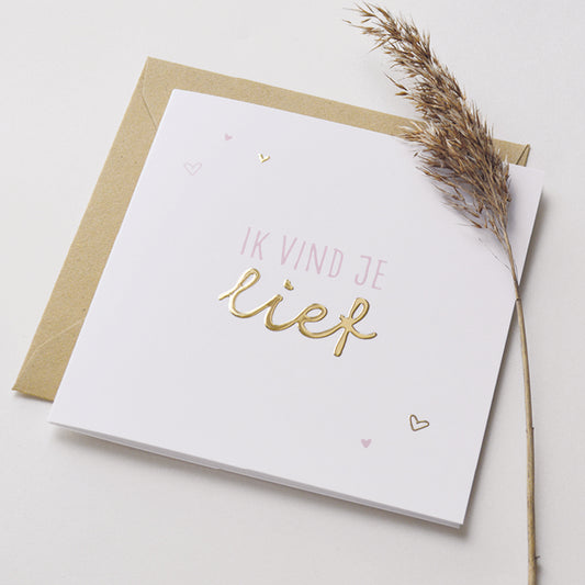 Wenskaart met goudfolie met de tekst ik vind je lief. Weergegeven met kraft envelop