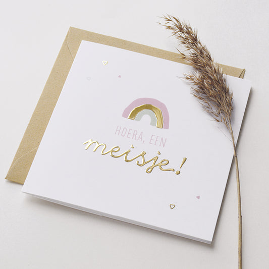 Wenskaart met goudfolie met de tekst hoera, een meisje! Weergegeven met kraft envelop