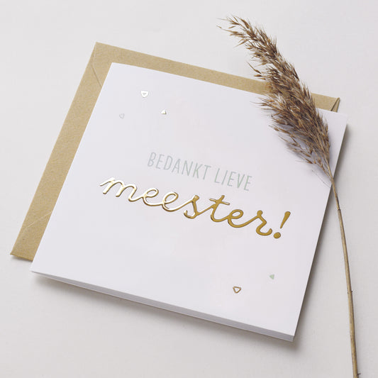 Wenskaart met goudfolie met de tekst bedankt lieve meester! Weergegeven met kraft envelop