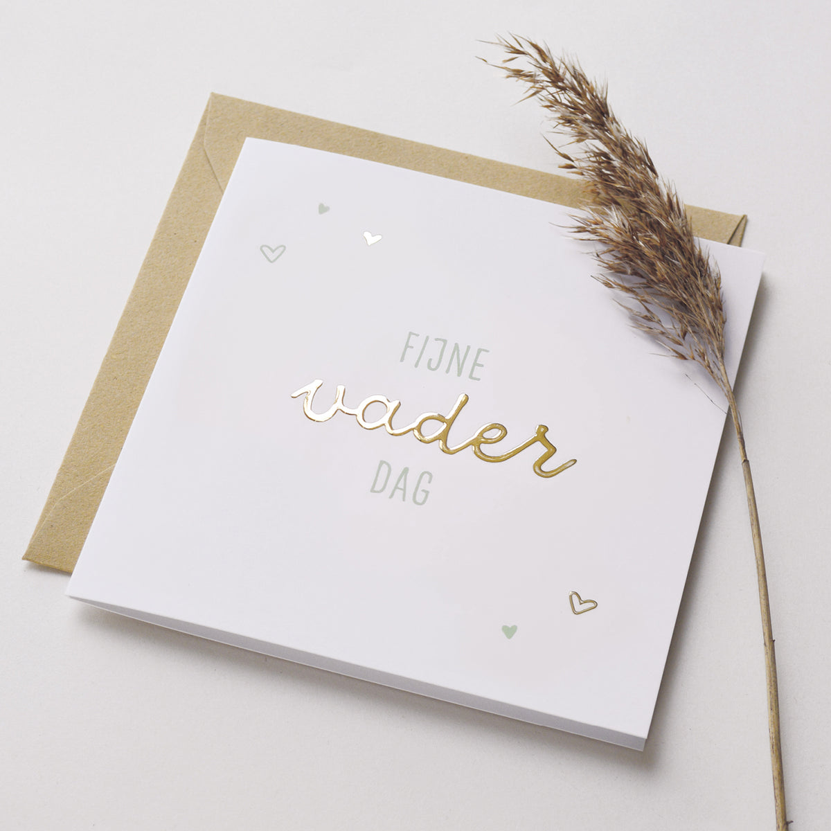 Wenskaart met goudfolie met de tekst fijne vaderdag. Weergegeven met kraft envelop