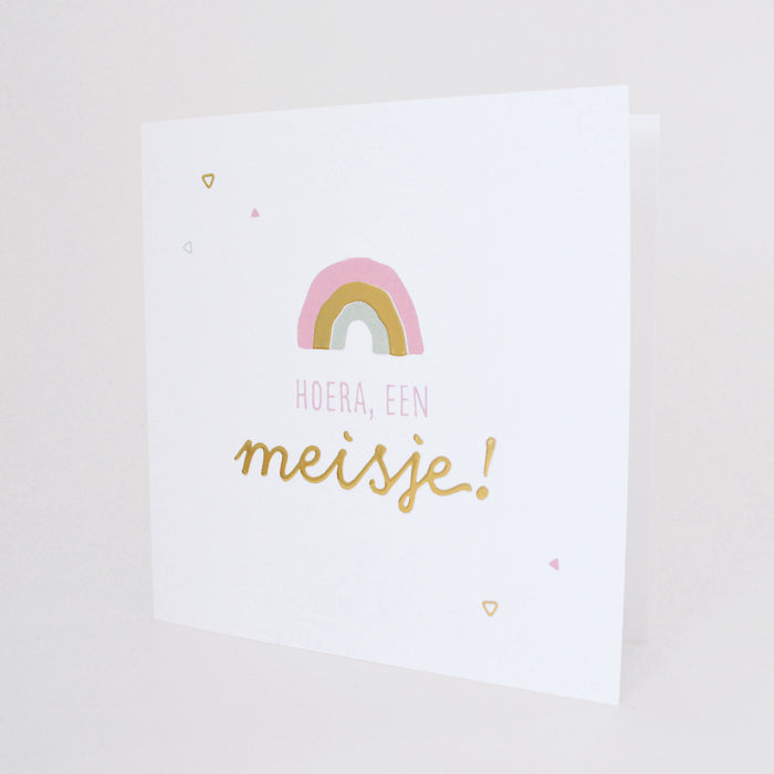 Afbeelding van staande wenskaart met hoera, een meisje! in goudfolie en een subtiel roze regenboogje boven de tekst. 